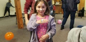 Kid in church fellowship hall showing off face paint