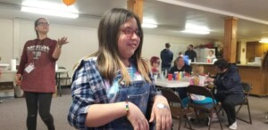 Kid in church fellowship hall with face painting happening in the background