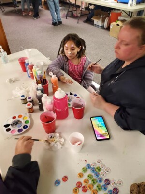 Kid in church fellowship hall getting face painted