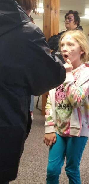 Face painted kid in church basement showing a look of surprise