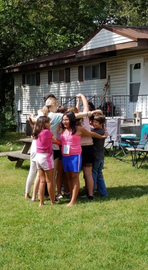 Kids in group hug in front of church