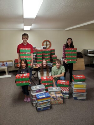 Church youth with Christmas shoe boxes as prepared as a charity outreach activity