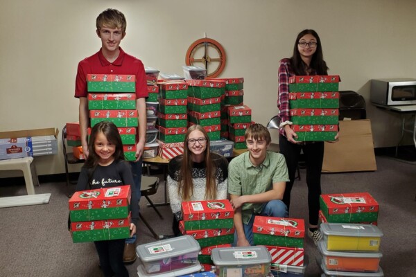 Church youth with Christmas shoe boxes as prepared as a charity outreach activity