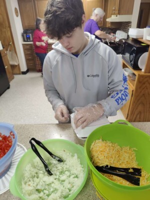 Youth helping prepare taco dinner during colcord church fundraiser
