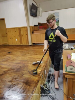 Church volunteer working to resurface church stage