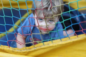 Kid staring at camera through play netting