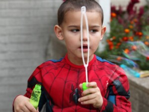 Kid blowing bubbles by the church